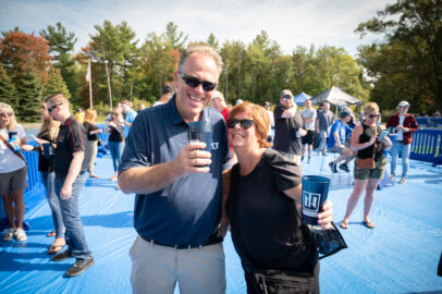 A photo of two happy friends of Northwood University taking part in Tavern 59 event at a Northwood football game.