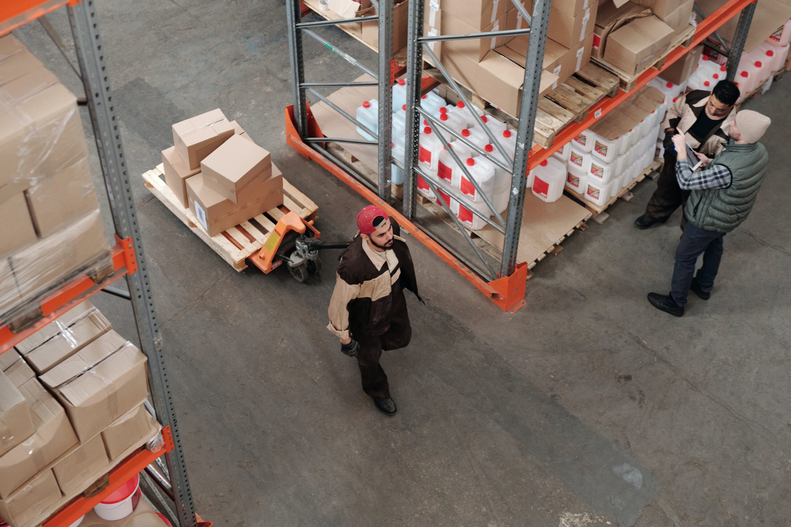 Workers pulling shipping boxes through a warehouse