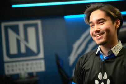 Northwood Esports Player smiling with the Esports lab behind him