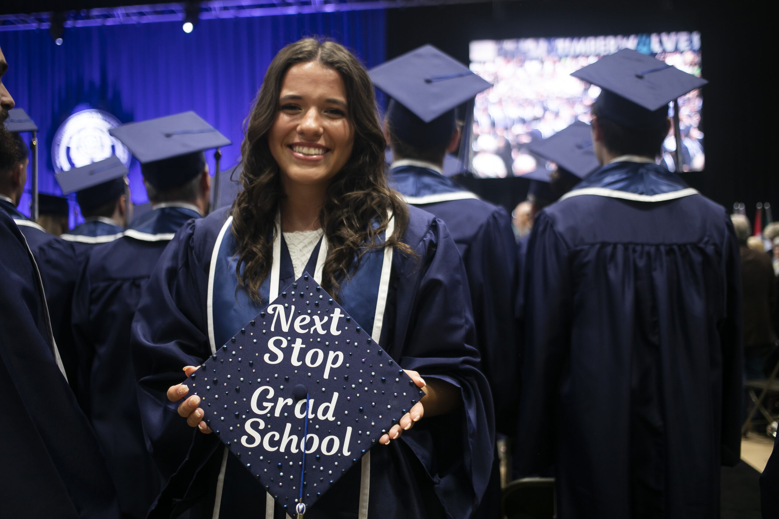 Undergraduate student holding a decorated cap at graduation