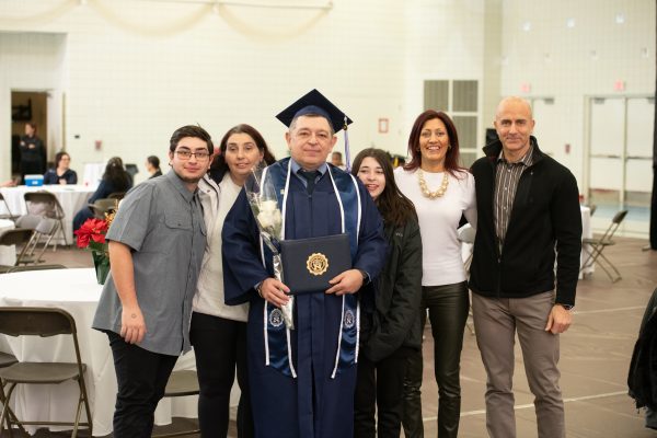 Adult student pictured with family on graduation day