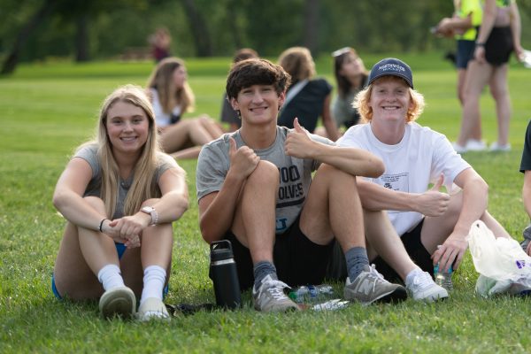 Students sitting on the grass in downtown Midland during Welcome Weekend