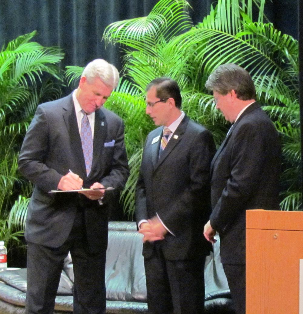 Northwood President Keith A. Pretty, JD signs the partnership agreement as Alfredo Ortiz and Dr. Tom Duncan look on.