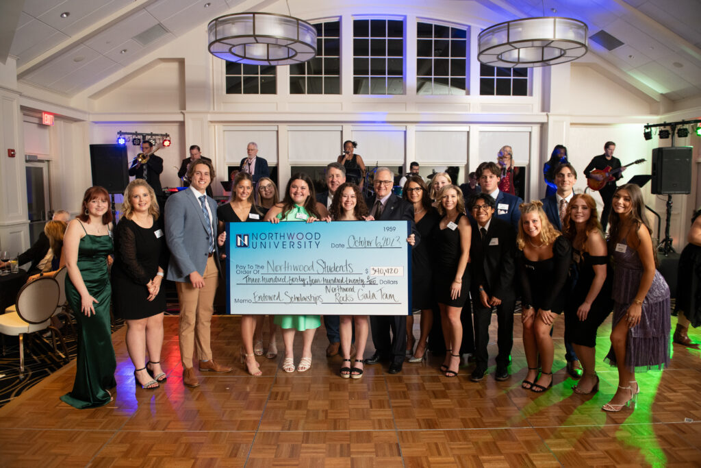 Students holding a big check from fundraising at the Auto Show Gala