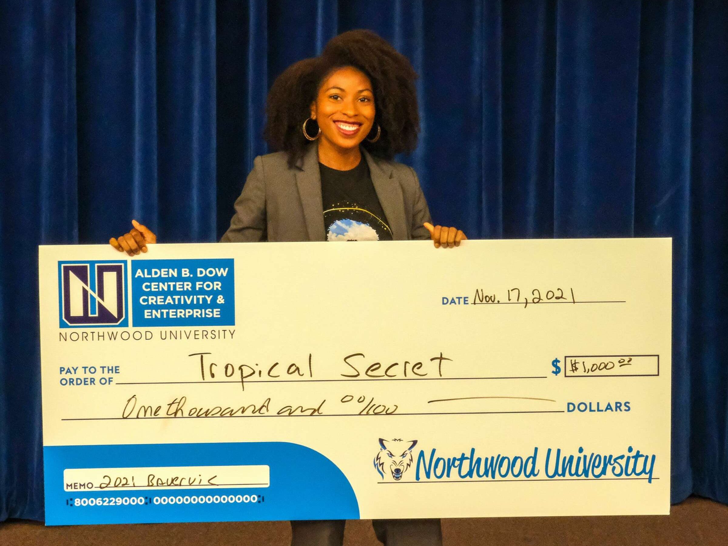 Student holding her prize check at the Bauveric Pitch Competition