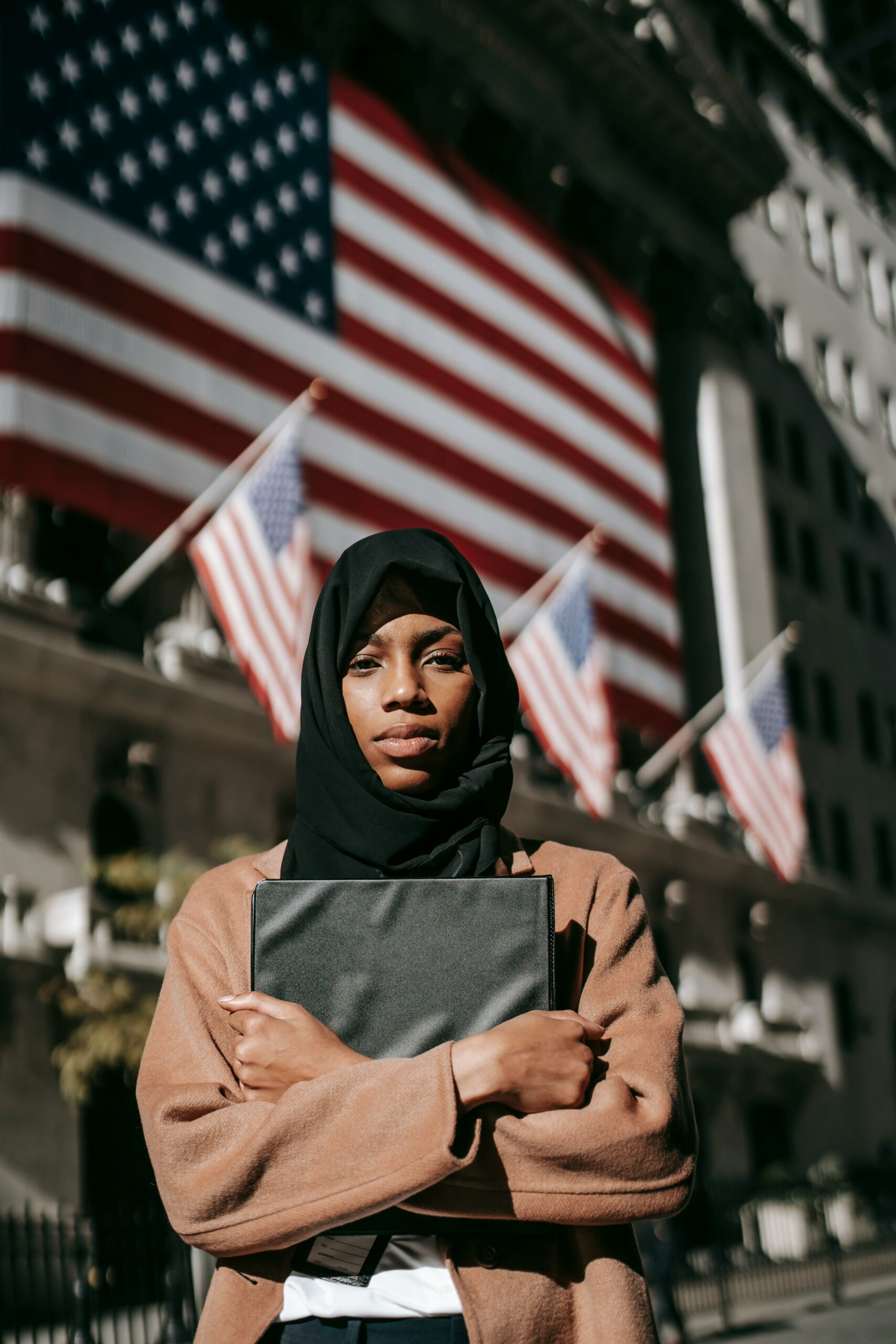Woman in a hijab standing in front of the American Flag